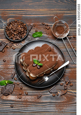 Classic tiramisu dessert on ceramic plate on wooden background 69095888