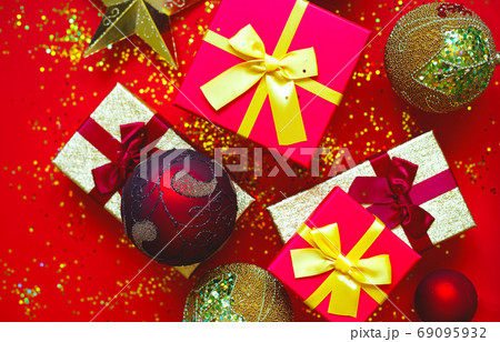 gift boxes with bows and Christmas toys on a red-gold background 69095932