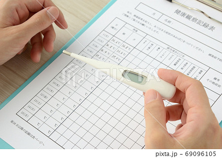 健康観察 検温の記録をとる人物の写真素材