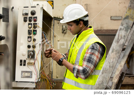 Engineers operating a cnc machine in factory 69096125