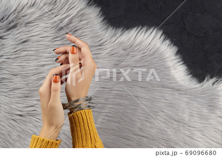 Manicured womans hand over furry background 69096680