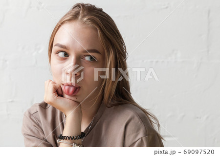 Funny Blond Teenage Girl Shows Tongue Close Upの写真素材