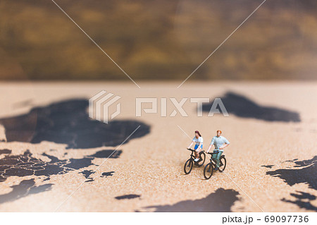 Miniature people travelers riding bicycle on world map , Traveli 69097736