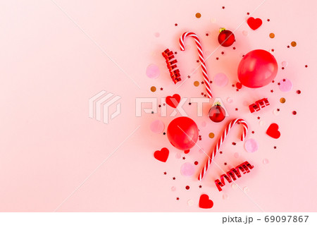 Red box with confetti, balloons, streamers and decoration on a pink background. Colorful celebration, birthday background. Flat lay, top view  69097867