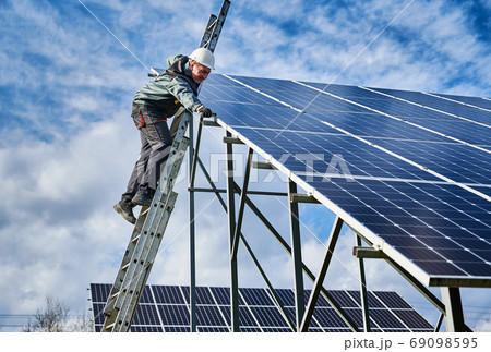 Male worker checking photovoltaic solar panel. 69098595
