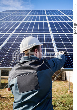Male technician installing photovoltaic blue solar module. 69098605