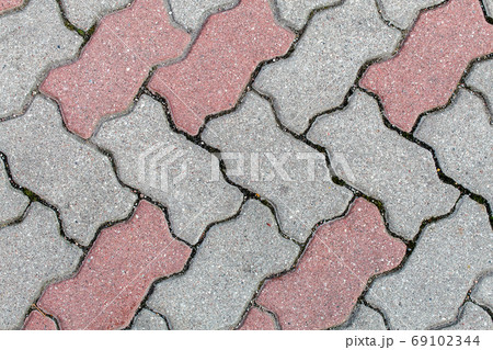 road paved with gray, yellow and brown sidewalk tiles. texture o road paved with gray, yellow and brown sidewalk tiles. texture o 69102344