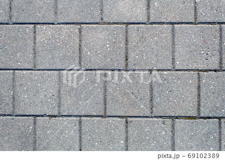 road paved with sidewalk tiles. texture of light gray bricks. road paved with sidewalk tiles. texture of light gray bricks. 69102389
