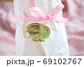 ピンクのリボンとBest Wishesシールのラッピング 69102767