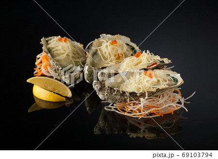 mussels in a shell with salad on a dark background 69103794