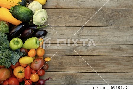 Many different bright, colorful vegetables on a wooden background Many different bright, colorful vegetables on a wooden background 69104236