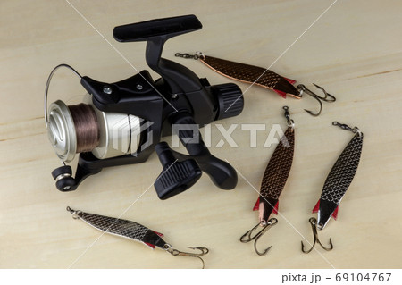 Fishing Reel and Fishing Lures on a Wooden Surface Fishing Reel and Fishing Lures on a Wooden Surface 69104767