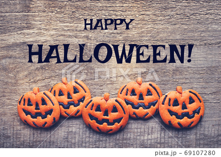 Halloween gingerbread cookies on wooden background. 69107280