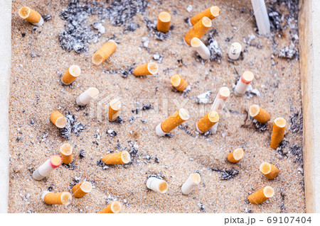Many Cigarette butts discarded in ashtray Many Cigarette butts discarded in ashtray 69107404