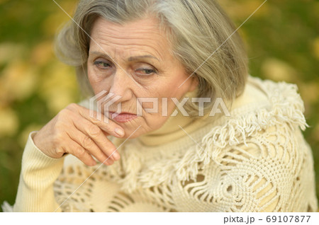 Portrait of sad, thoughtful senior woman in park Portrait of sad, thoughtful senior woman in park 69107877
