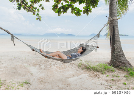 Beautiful woman sleeping on hammock on the beach, Moment from the vocation. Beautiful woman sleeping on hammock on the beach, Moment from the vocation. 69107936