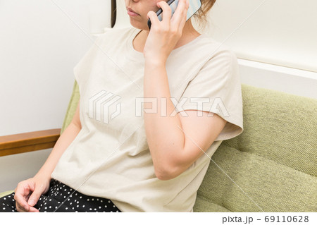 ソファーに座って電話をする女性 69110628