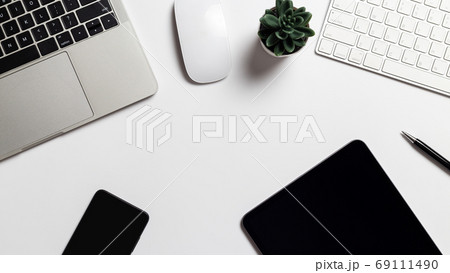 Top view workspace office desk with notebook computer and office supplies on white background 69111490