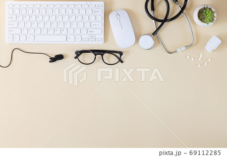 Online medical consultation background. Keyboard, stethoscope, microphone and other supplies top view 69112285