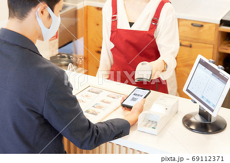 スマホに表示したバーコードを読み取る店員とお客 69112371