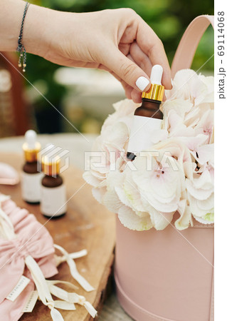Woman taking essential oil bottle Woman taking essential oil bottle 69114068