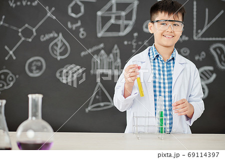 Schoolboy mixing colorful liquids Schoolboy mixing colorful liquids 69114397