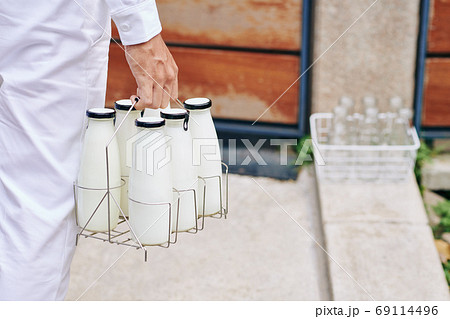 Delivery man carrying milk 69114496