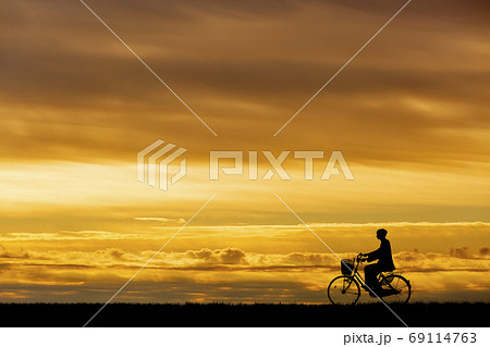 夕陽を背景に自転車通学する男子高校生のシルエット 夕陽を背景に自転車通学する男子高校生のシルエット 69114763