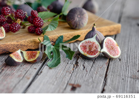 Fresh juicy figs and blackberries on a dark background 69116351