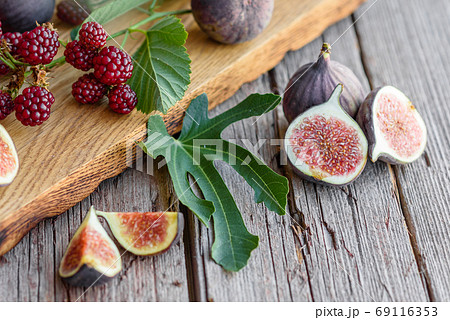 Fresh juicy figs and blackberries on a dark background 69116353