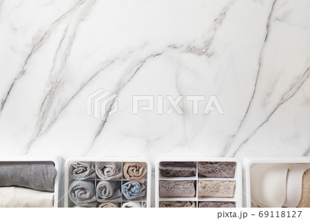 Womans underwear, pajamas and socks neatly folded and placed in closet organizer drawer divider on white marble table. Womans underwear, pajamas and socks neatly folded and placed in closet organizer drawer divider on white marble table. 69118127
