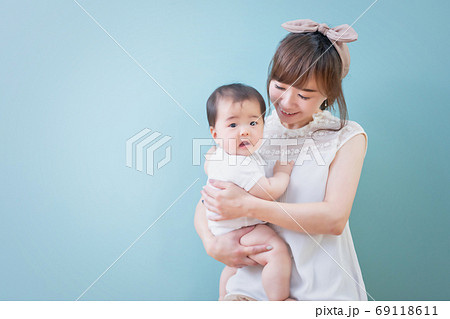 赤ちゃんを抱っこする笑顔の若いママ 69118611