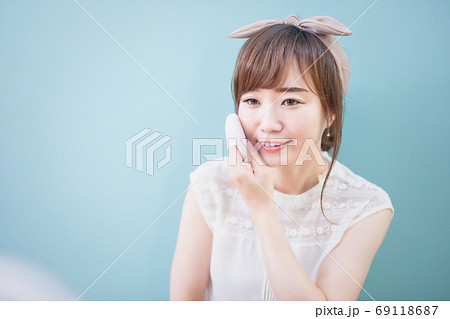 ファンデーションを頬に塗るメイク中の女性 69118687