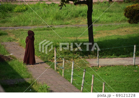 バングラデシュのダッカ　未完の城跡のラールバーグ・フォート　美しい庭園と歩道を歩くイスラム教徒の女性 69121228
