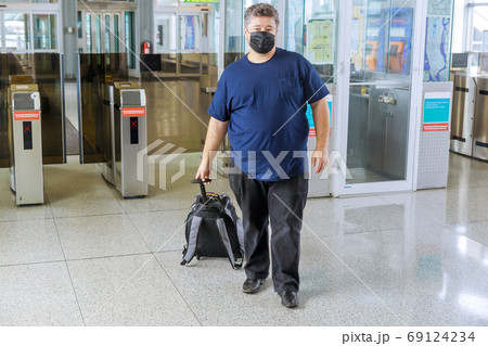 Man wearing face mask for flight at airport 69124234
