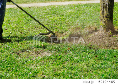 A municipal worker in an lawn mower mows fresh, A municipal worker in an lawn mower mows fresh, 69124485