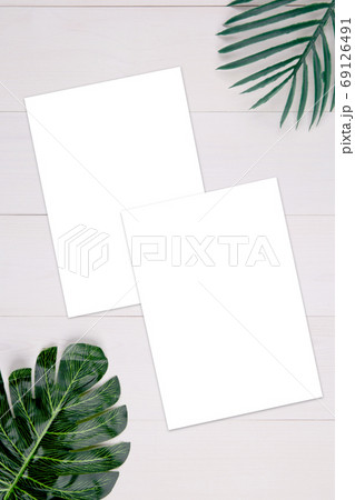 Blank paper sheet copy space with mockup and leaf on wooden table. Blank paper sheet copy space with mockup and leaf on wooden table. 69126491