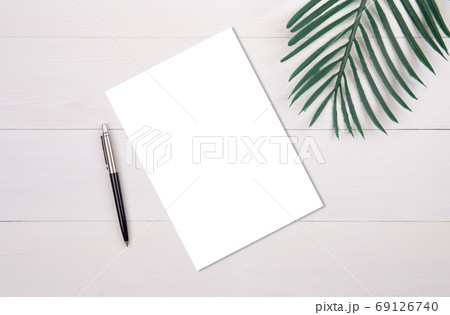Blank paper sheet copy space with mockup and leaf on wooden table. 69126740