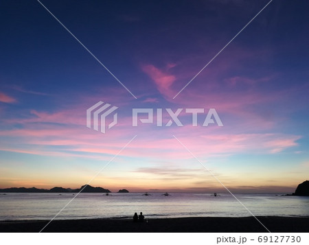 大自然のリゾートで夕焼けを眺めるカップル【El Nidoビーチ】 大自然のリゾートで夕焼けを眺めるカップル【El Nidoビーチ】 69127730