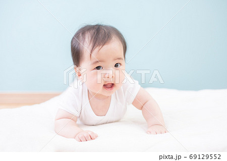 うつ伏せになった笑顔の赤ちゃん 69129552