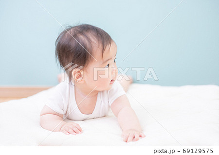 うつ伏せになった笑顔の赤ちゃん うつ伏せになった笑顔の赤ちゃん 69129575