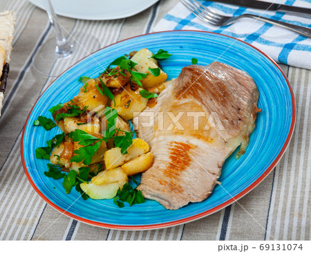 Roasted pork chop with grilled potatoes garnish 69131074