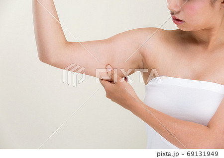 二の腕をつまむ女性 の写真素材