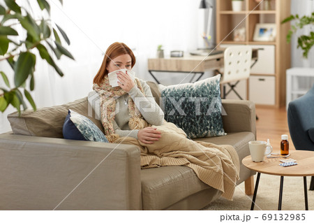 sick woman blowing nose in paper tissue at home sick woman blowing nose in paper tissue at home 69132985