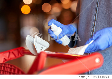 woman cleaning shopping cart handle with sanitizer woman cleaning shopping cart handle with sanitizer 69133053