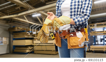 woman or builder with gloves and working tools woman or builder with gloves and working tools 69133115