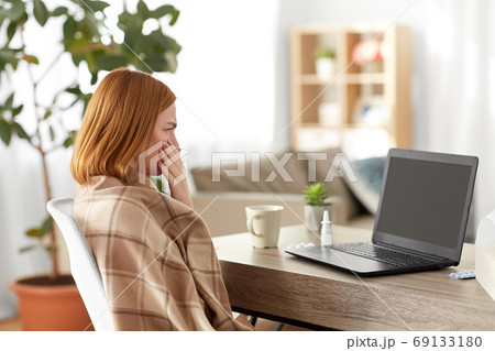 sick woman having video call on laptop at home 69133180