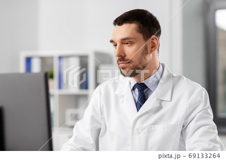 male doctor with computer working at hospital male doctor with computer working at hospital 69133264