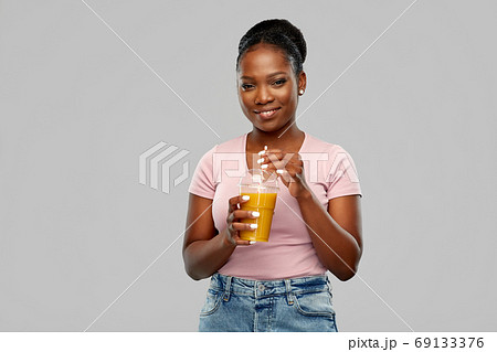 happy african american woman drinking orange juice happy african american woman drinking orange juice 69133376