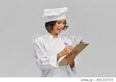 smiling female chef in toque with clipboard 69133754
